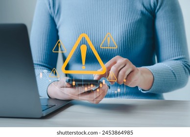 Businessman using smartphone and notebook at work desk with warning sign for caution in investment, warning of economic situation, risk in business investment.