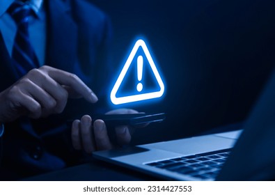 Businessman using smartphone showing warning triangle and exclamation sign icon Warning of dangerous problems Server error. Virus. Maintenance concept. caution internet technology network security
