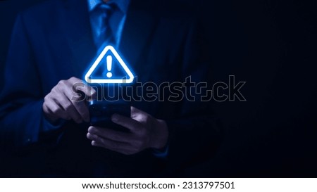 Businessman using smartphone showing warning triangle and exclamation sign icon Warning of dangerous problems Server error. Virus. Maintenance concept. caution internet technology network security
