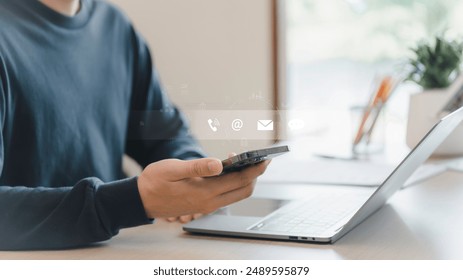 Businessman using a smartphone and touching on virtual screen contact icons, Contact us or Customer support hotline people connect, symbol telephone, mail, address and mobile phone. - Powered by Shutterstock