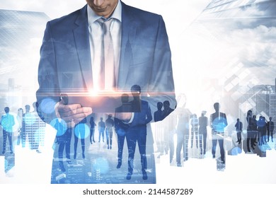 Businessman using tablet with abstract crowd of businesspeople standing on abstract bright city background. Teamwork and success concept. Double exposure - Shutterstock ID 2144587289