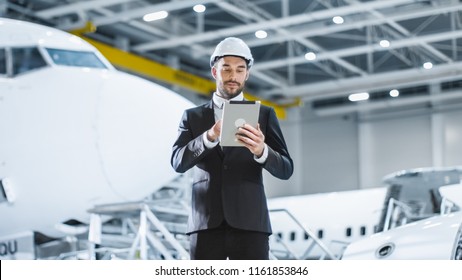 Businessman Using Tablet In Aircraft Maintenance Terminal