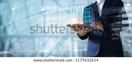 Businessman using tablet analyzing sales data and economic growth graph chart.  Business strategy.  Digital marketing.