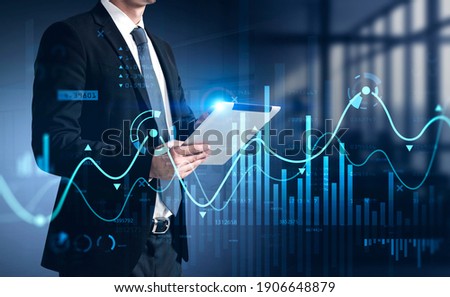 Businessman using tablet with business report hologram. Business and financial success concept. double exposure. Forex Chart