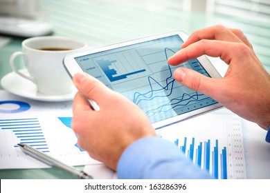 Businessman Using Tablet Computer To Work With Financial Data