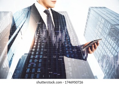 Businessman using tablet and digital falling chart hologram on city background. Business crisis concept. Double exposure.