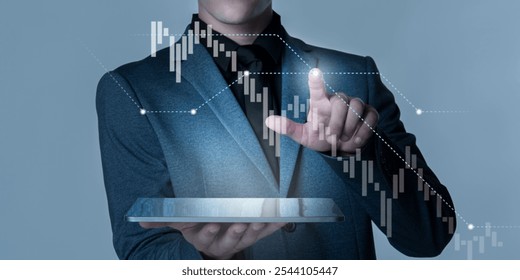 Businessman using tablet with financial graphs. Male professional in suit analyzing financial data. Businessman interacting with digital financial graphs and data with copy space. - Powered by Shutterstock