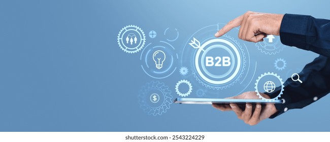 Businessman using tablet and finger touch b2b glowing gears hologram, lightbulb, target audience, financial marketing icons on blue background. Concept of business to business and e-commerce - Powered by Shutterstock