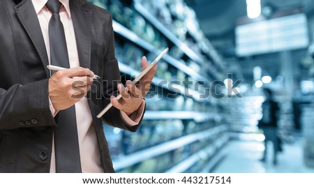 Businessman using the tablet on Abstract blurred photo of store in department store bokeh background, business shopping concept
