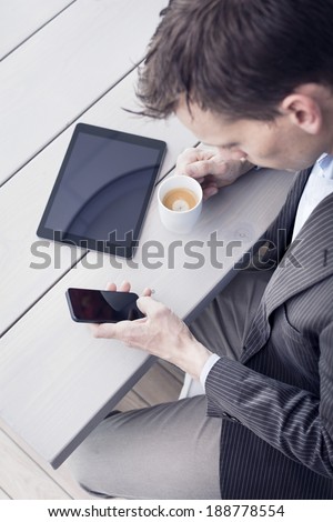 Businessman using tablet pc and smartphone.