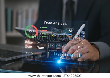 Businessman using tablet and stylus with virtual data analysis dashboard hologram. Concept of business intelligence, big data analytics, global financial statistics and corporate performance report.
