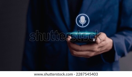 businessman using utilizes his smartphone as an AI assistant, effectively issuing voice commands through its microphone symbol, enhancing productivity with cutting-edge technology.