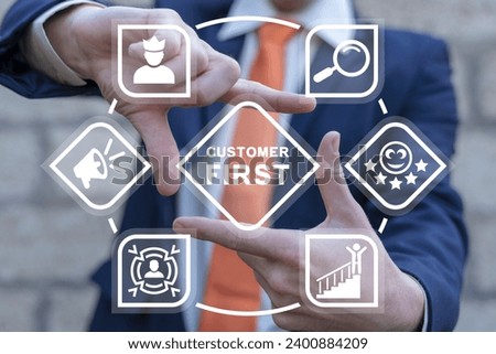 Businessman using virtual interface sees inscription: CUSTOMER FIRST. Client centricity business orientation. Customer first concept. VIP client servcie. Customer relationship management (CRM).