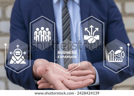 Businessman using virtual interface sees text: BUSINESS EXPANSION. Web business expansion such as teamwork, sales, marketing, strategy, distribution network, franchise. Concept of business expansion.