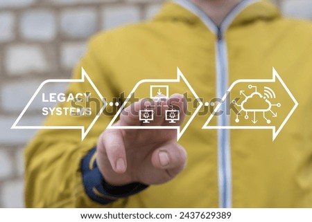 Businessman using virtual touch screen presses inscription: LEGACY SYSTEMS. Legacy System Business Technology Inter operability Modernization concept.