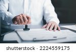 Businessman validates and manages business documents and agreements, signing a business contract approval of contract documents confirmation or warranty certificate,approval stamp