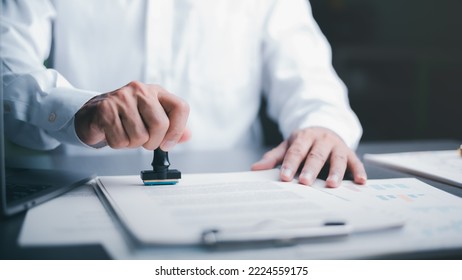 Businessman validates and manages business documents and agreements, signing a business contract approval of contract documents confirmation or warranty certificate,approval stamp - Shutterstock ID 2224559175