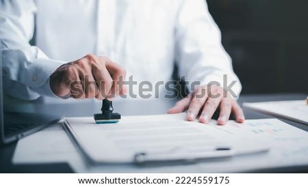 Businessman validates and manages business documents and agreements, signing a business contract approval of contract documents confirmation or warranty certificate,approval stamp