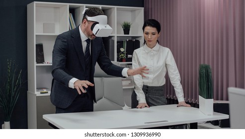 Businessman in vr glasses and manager woman in a modern office, uses a transparent screen tablet on table, template for effect of a hologram and HUD motion graphics.