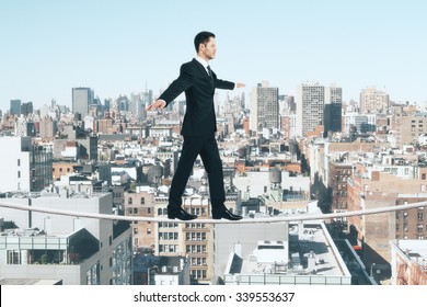 Businessman is walking on a rope at city background - Powered by Shutterstock