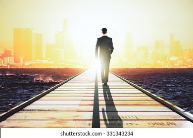 Businessman walking on a straight road to the big city at sunrise - Powered by Shutterstock