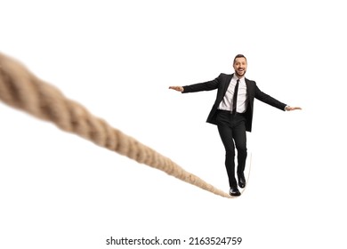 Businessman walking on a tightrope and smiling isolated on white background - Powered by Shutterstock