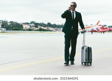 Businessman, walking and phone call at airport for travel, communication and booking hotel with sunglasses. Executive, suitcase and mobile conversation for private jet, plane and international flight - Powered by Shutterstock