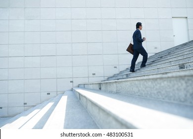 Businessman Walking Up The Stairs, Side View