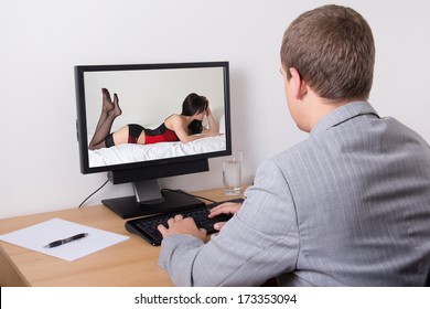 businessman watching erotic pictures in computer at work in office