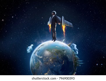Businessman wear a rocket suit to lift from Earth planet , Business start up and travel concept .Extremely detailed image including elements furnished by NASA.