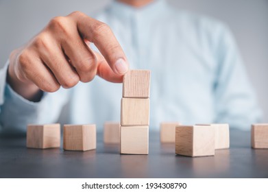 Businessman wearing a blue shirt, arranging the empty wooden blocks with his hands. Which is placed on a white wooden table. Business strategy and action plan. Copy space. - Powered by Shutterstock