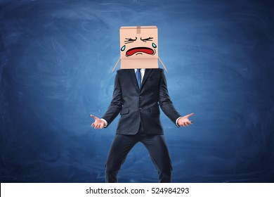 Businessman wearing cardboard box with drawn crying face on his head. on blue chalkboard background. Anonymous person. Issues of small business. Bear losses. - Powered by Shutterstock