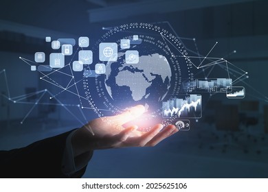 Businessman wearing formal suit is holding a digital interface with globe, cloud data, padlock, coin icons. Blurred office in the background. Concept of international business and communication