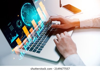 Businessman wearing formal wear typing on laptop sitting at office workplace in background. Digital interface with virtual globe, bar diagram, financial graph. Concept of modern technology, trading