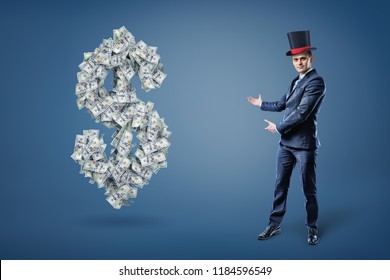 A Businessman Wearing A Magician's Hat And Presents A Large Dollar Sign Made Of Many Bills. Money And Prosperity. Easy Money. Get Rich With Simple Trick.