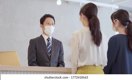 businessman wearing mask talking to customer - Powered by Shutterstock