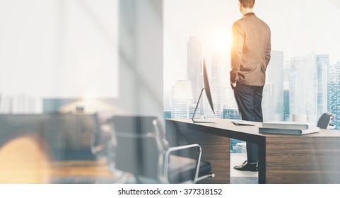 Businessman wearing modern suit and looking at the city in contemporary office. Workspace loft with panoramic windows.  - Powered by Shutterstock