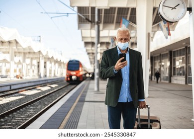 A businessman wearing protective face mask waiting for the train. A man on the train station wearing protective face mask. - Powered by Shutterstock