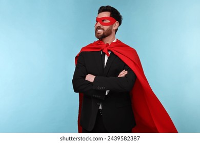 Businessman wearing red superhero cape and mask on light blue background - Powered by Shutterstock