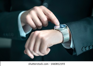 Businessman wearing smart watch with banking, finance or business report app. Man in suit using wearable gadget for work. Hybrid smartwatch with touch screen and metal band. People with wearables. - Powered by Shutterstock