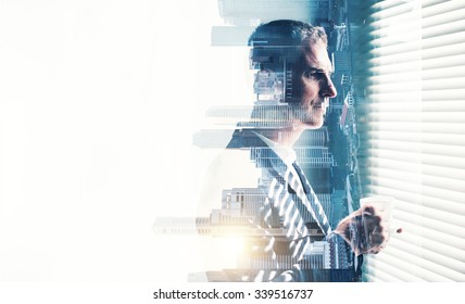 Businessman wearing suit and looking at the window. Double exposure city on sunrise. Horizontal - Shutterstock ID 339516737