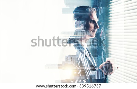 Businessman wearing suit and looking at the window. Double exposure city on sunrise. Horizontal