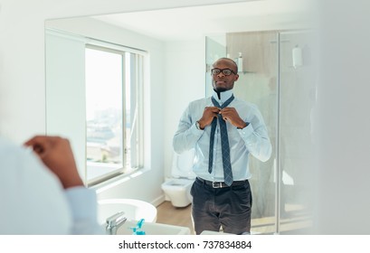 Businessman Wearing A Tie Looking At The Mirror. Man Dressing Up Looking At The Mirror In Bathroom.