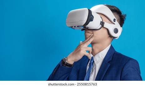 Businessman wearing VR headset demonstrating virtual reality training or program control on blue background - Powered by Shutterstock