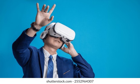 Businessman wearing VR headset demonstrating virtual reality training or program control on blue background - Powered by Shutterstock