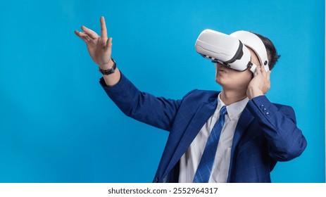 Businessman wearing VR headset demonstrating virtual reality training or program control on blue background - Powered by Shutterstock