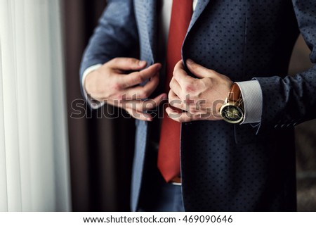 Businessman wears a jacket,male hands closeup,groom getting ready in the morning before wedding ceremony
