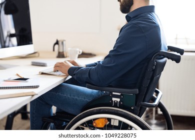 Businessman In Wheelchair Working In His Office.