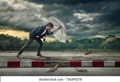 Businessman with white umbrella protecting himself from the storm.  Business heavy tasks and problems concept. - Powered by Shutterstock