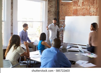 Businessman At Whiteboard In Brainstorming Meeting